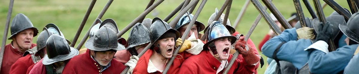 Opposing re-enactors in red and blue scream as they engage in a push of pike at the Pikes and Plunder Civil War Festival